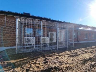 Inhägnad av luftvärmepumpar med gånggrind på skola